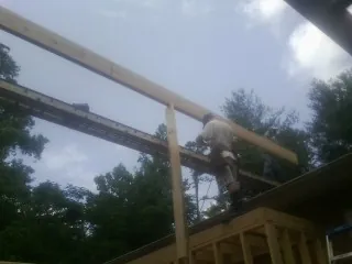 Carpenter setting a ridge beam over a new addition frame — Ice Dam Removal by Roofing Brothers in Douglas